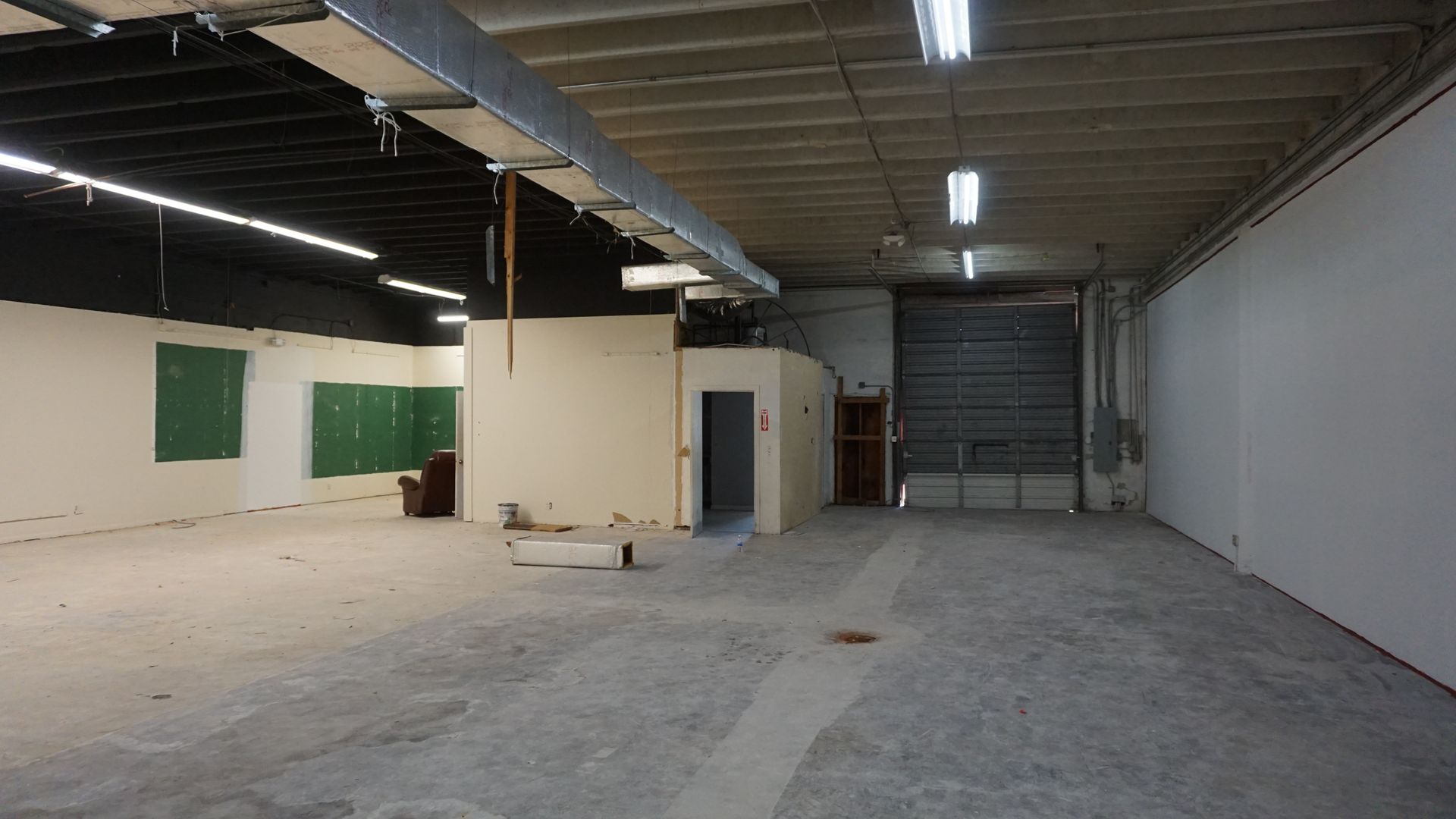 An empty warehouse with a green board on the wall