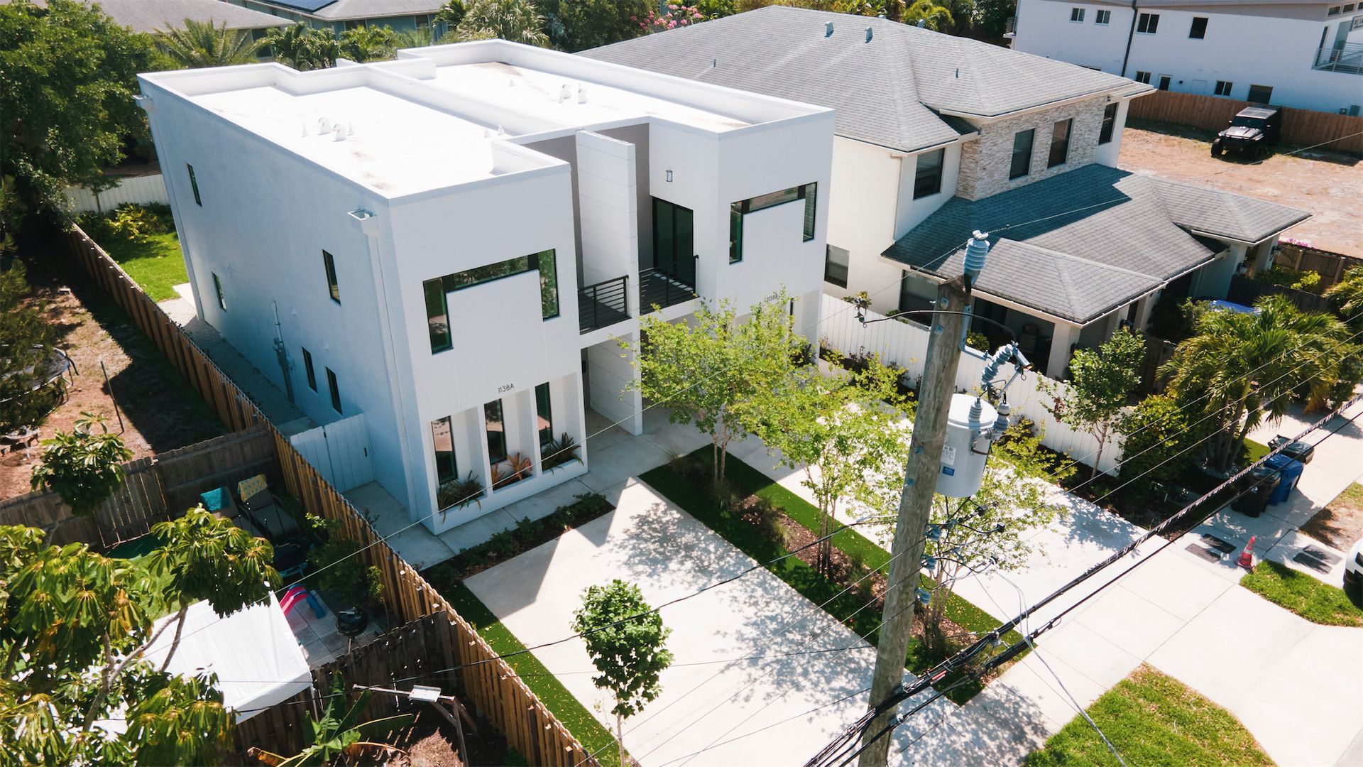 an aerial view of a large white house in a residential area
