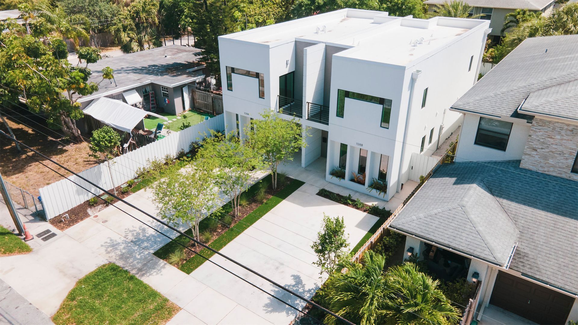 an aerial view of a white house in a residential area