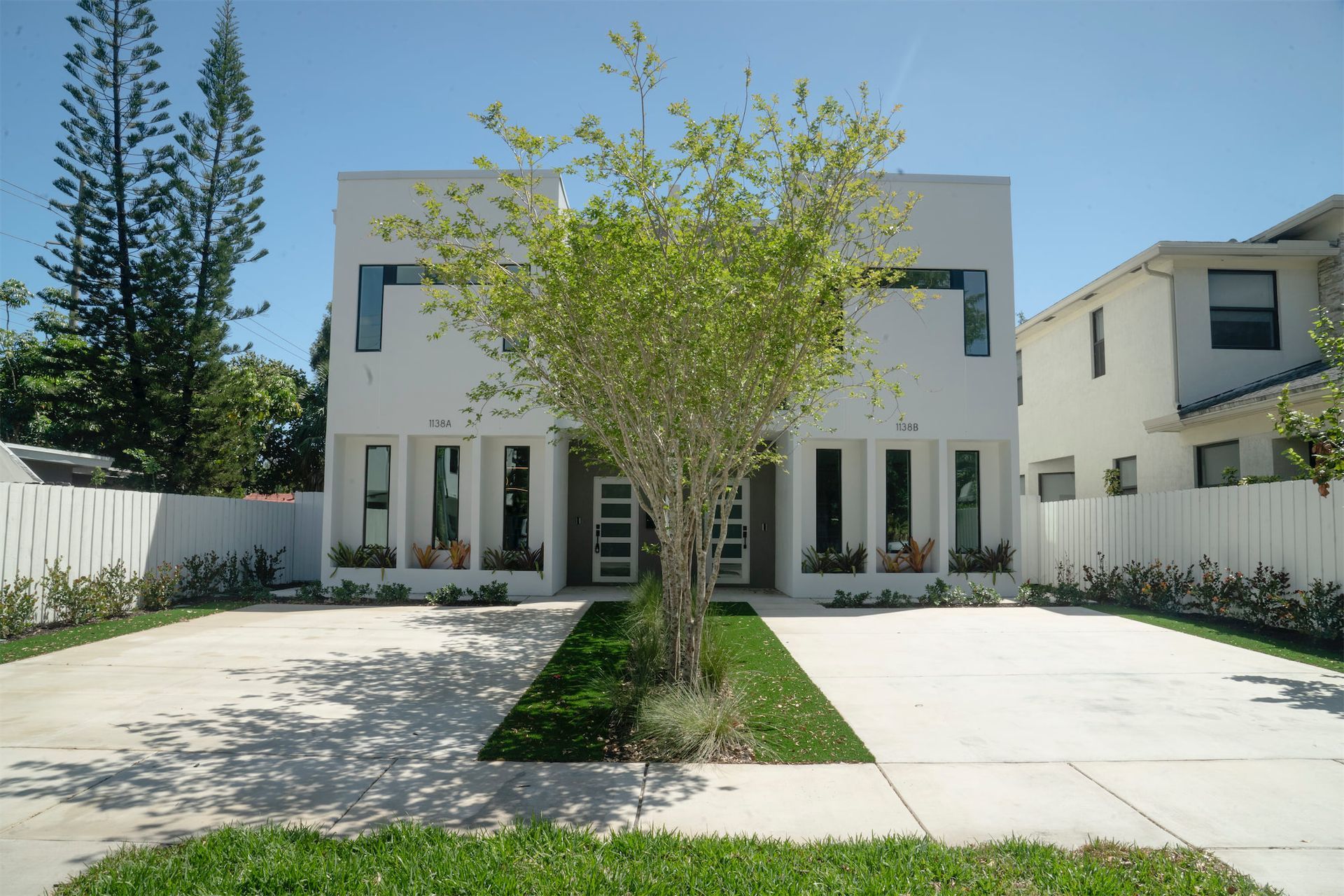 a white house with a tree in front of it