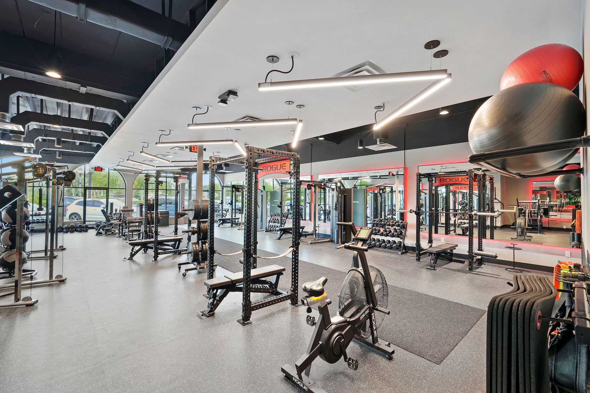 A large gym filled with lots of exercise equipment.