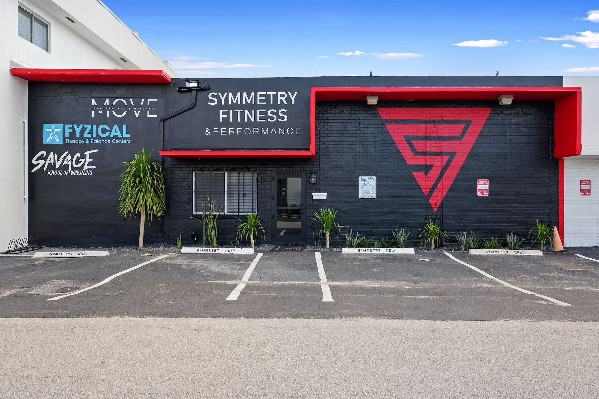A gym called symmetry fitness has a parking lot in front of it
