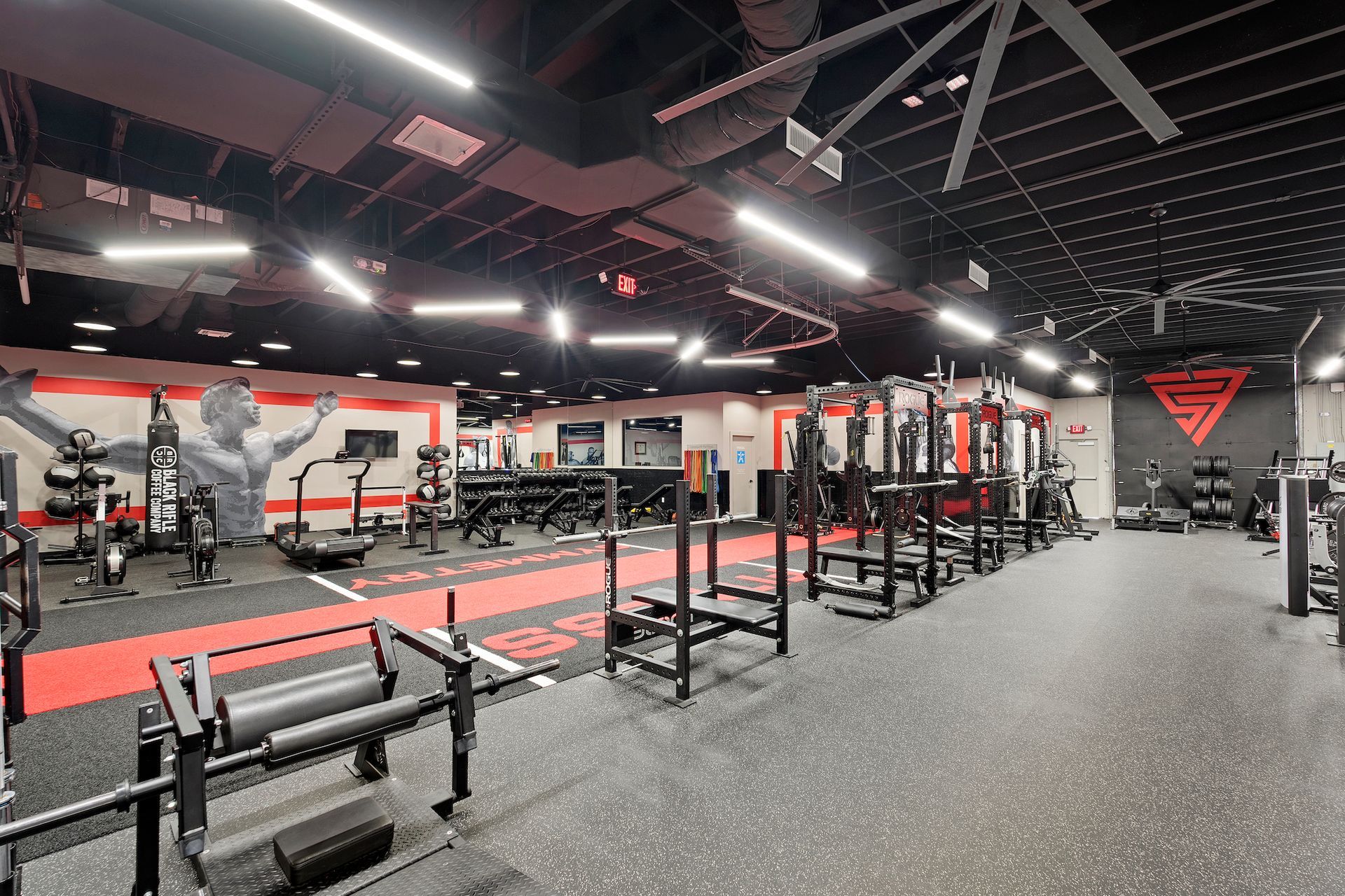 A large gym filled with lots of exercise equipment.