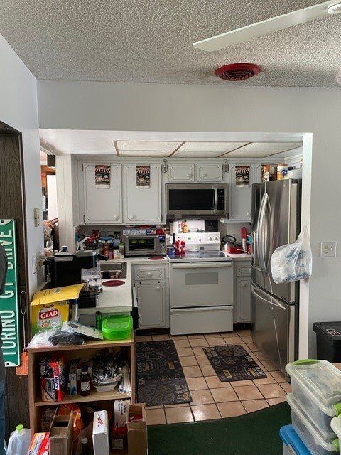 Small, cluttered, outdated kitchen.
