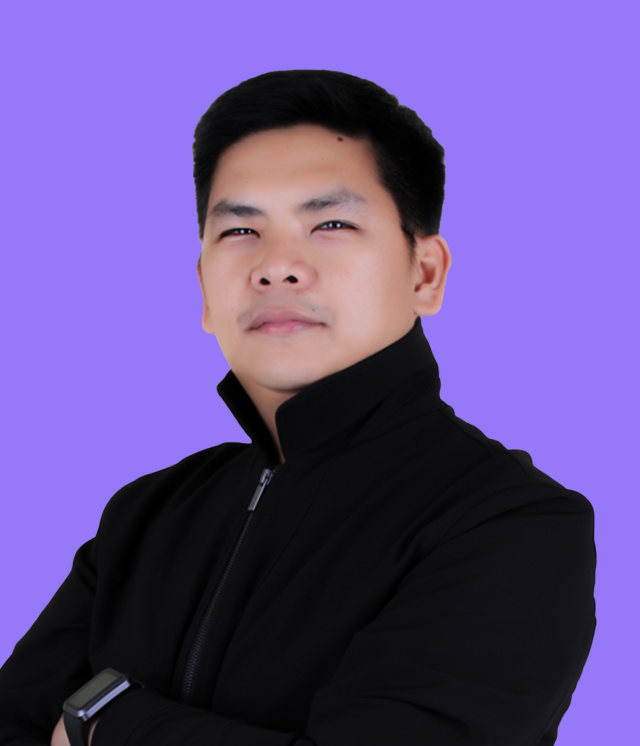 A man in a suit and tie is standing in front of a purple background