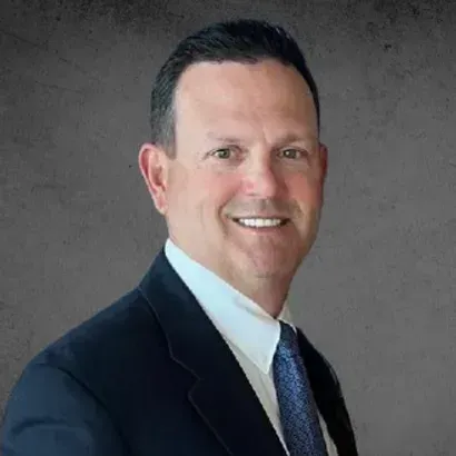 A man in a suit and tie is smiling for the camera.