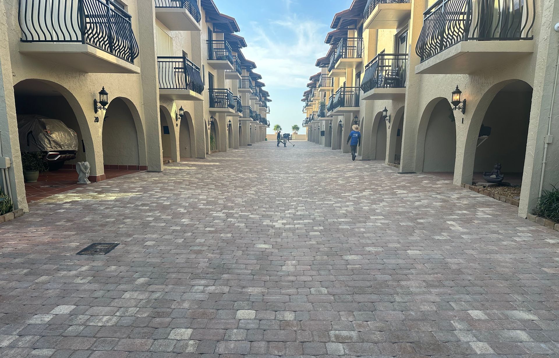 A brick driveway leading to a row of apartment buildings.