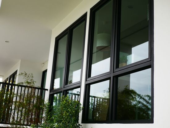 A white building with black windows and a balcony. A white building with black windows and a balcony.