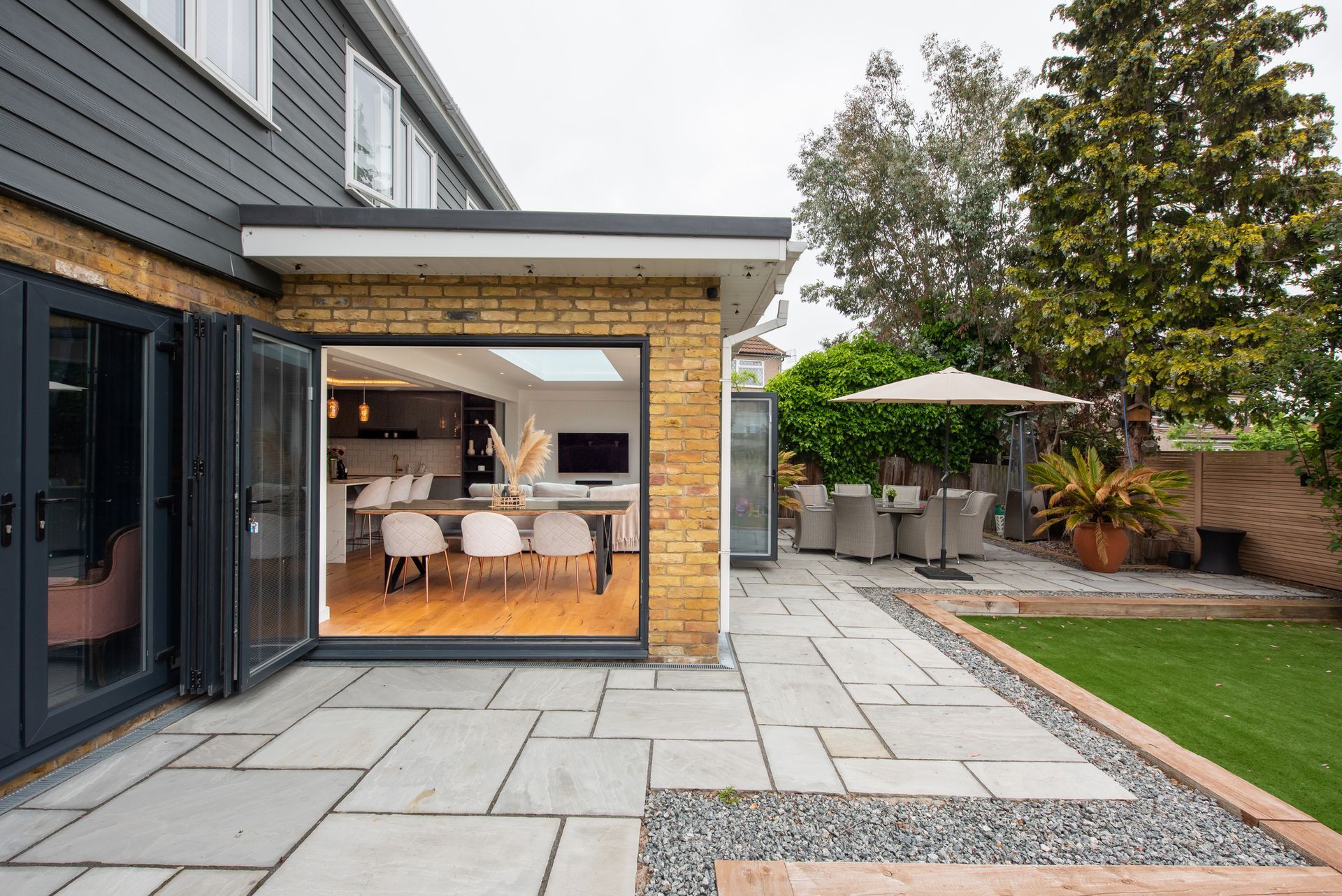 A house with a patio and a table and chairs in the backyard.