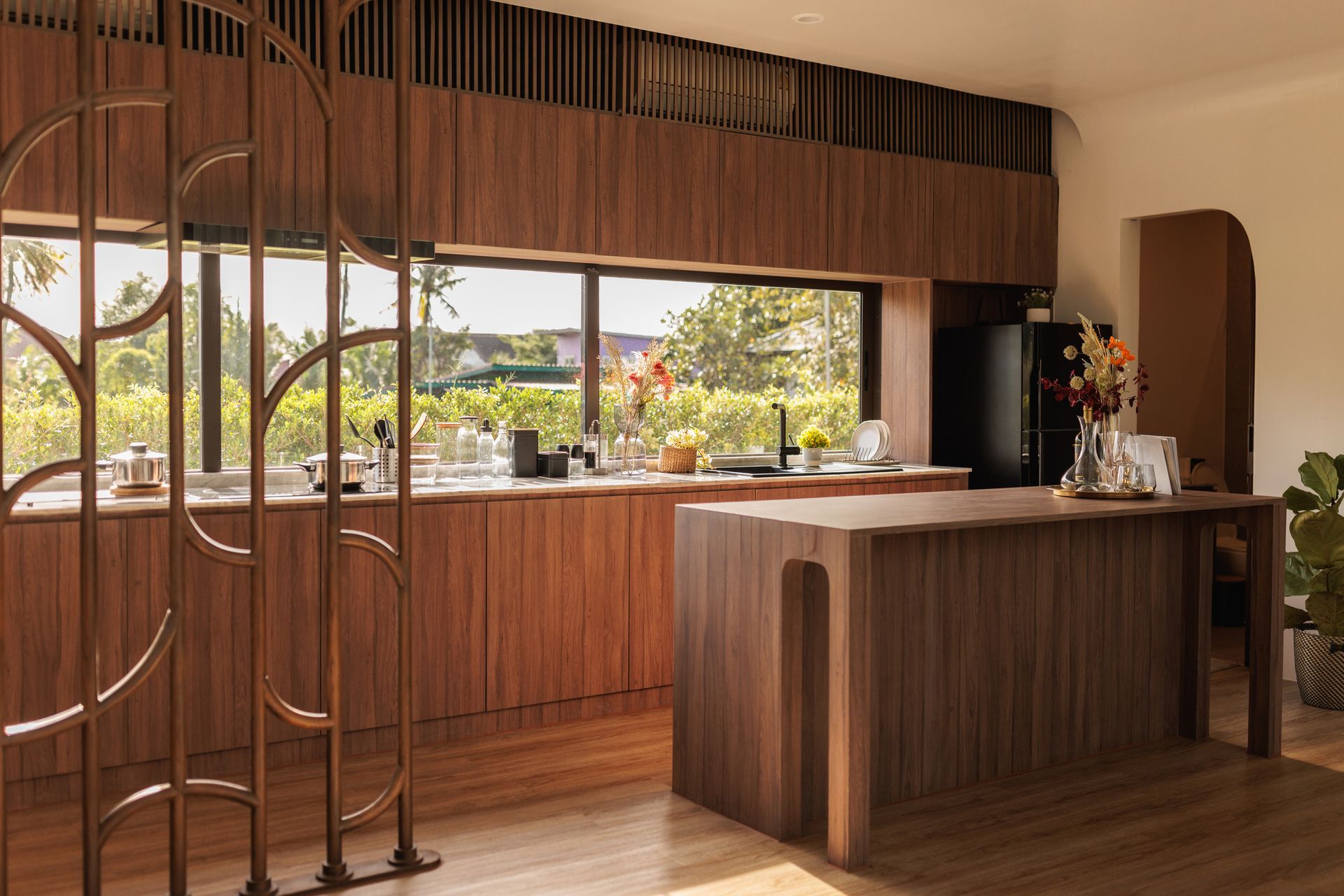 A kitchen with wooden cabinets and a large island in the middle of the room.