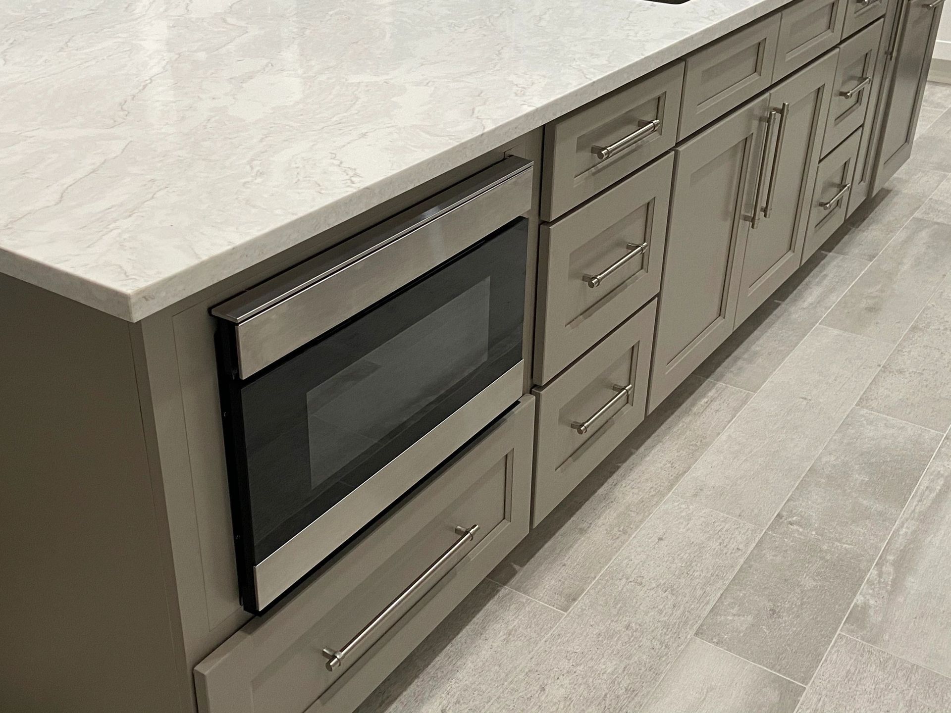 A kitchen with stainless steel appliances and gray cabinets. A kitchen with stainless steel appliances and gray cabinets.