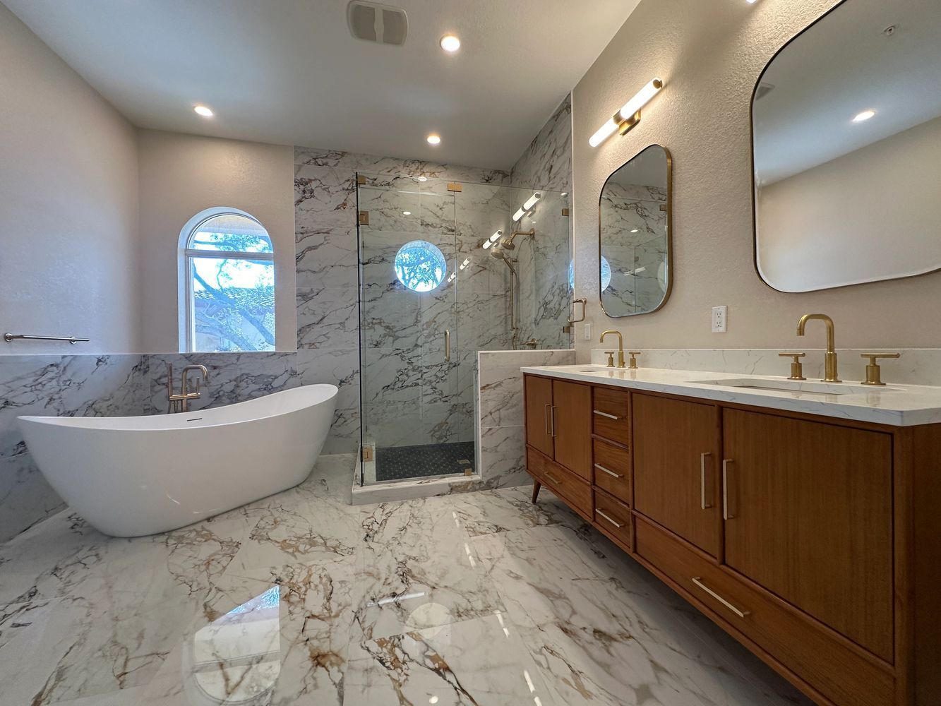 A bathroom with a bathtub , sink , toilet and shower.