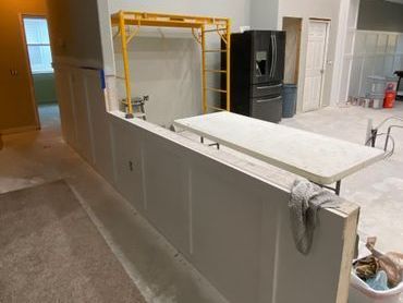 A kitchen under construction with a table and a refrigerator. A kitchen under construction with a table and a refrigerator.