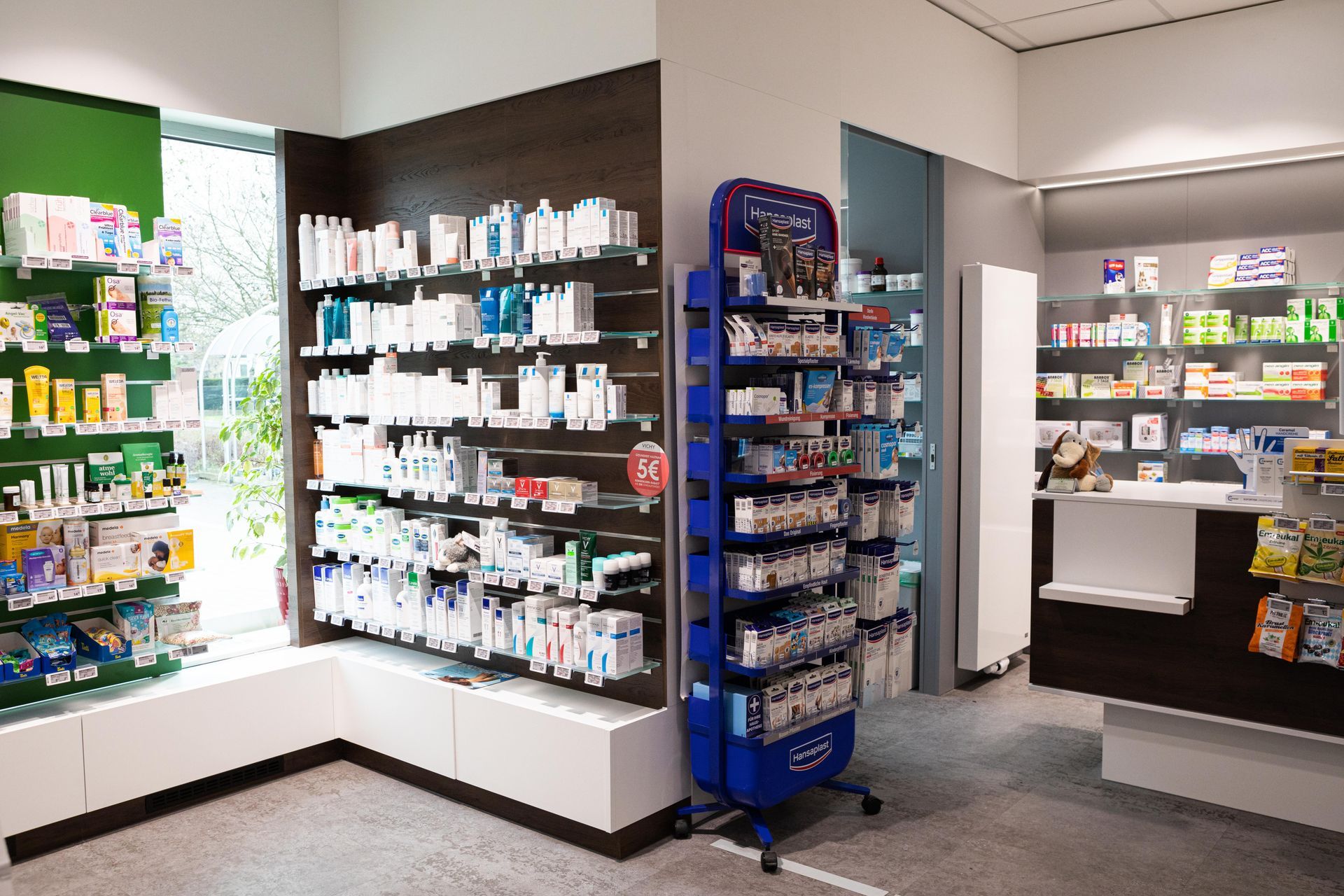 Apothekeninnenraum mit Medikamentenregalen und einem Ausstellungsständer.