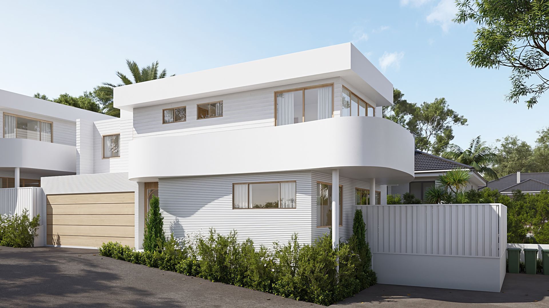 White modern two-story house with curved balcony and wooden garage door. Green shrubs and trees surround — Gracia Building Design In Kiama, NSW