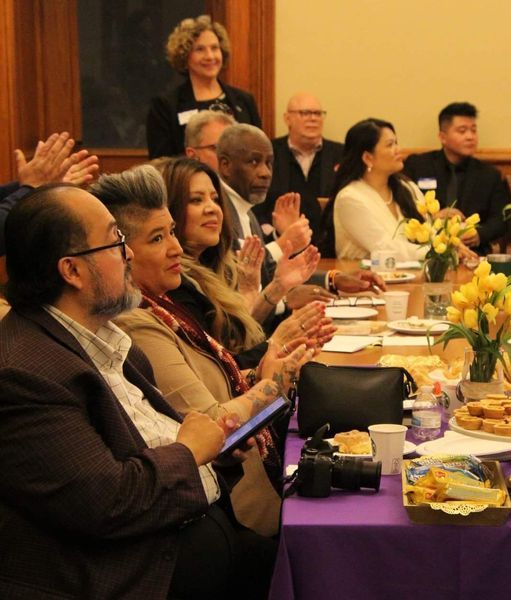 Members of the IUC and lawmakers sitting around a table applauding.