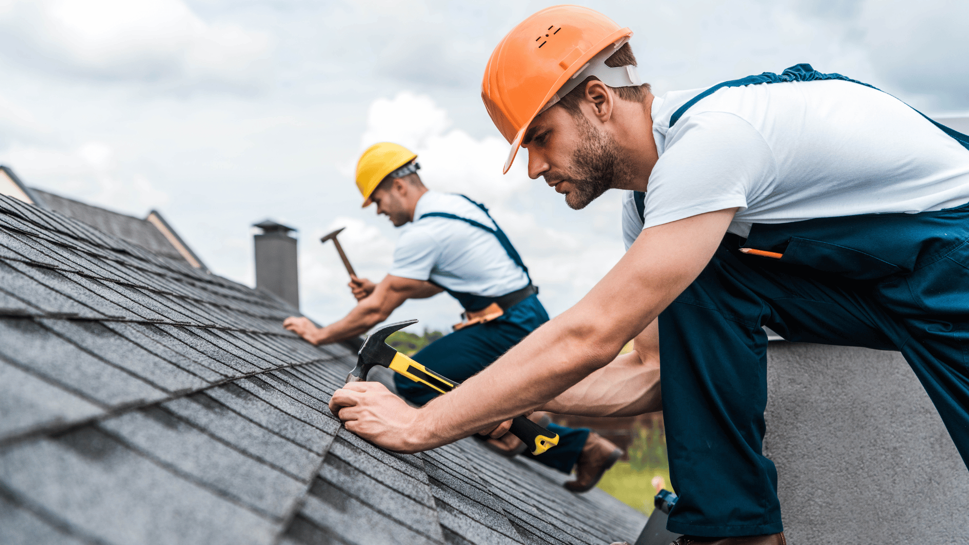 Two men are working on the roof of a house.