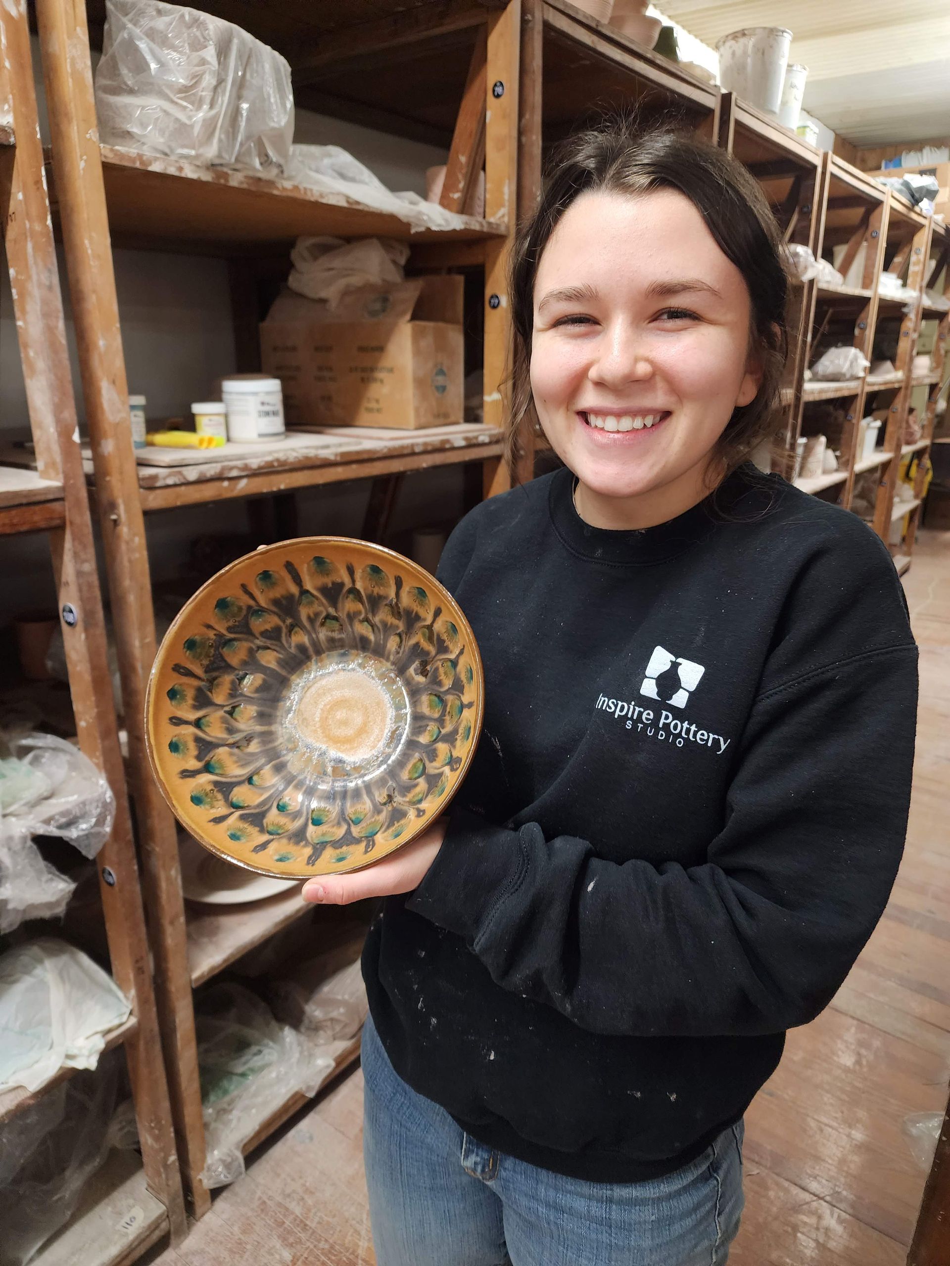 A woman in a black sweater is holding a plate