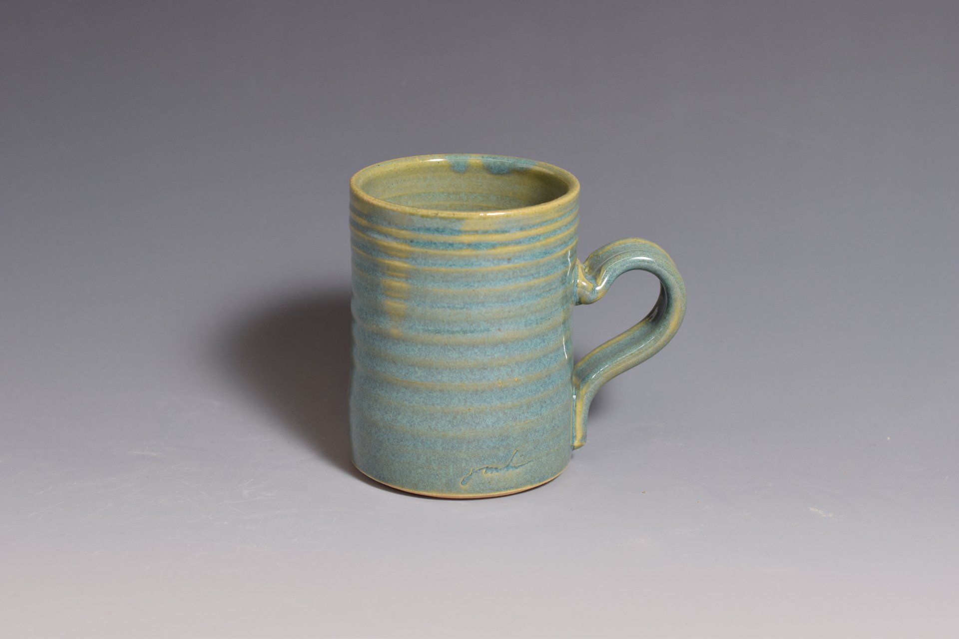 a blue and yellow mug with a handle is sitting on a table .