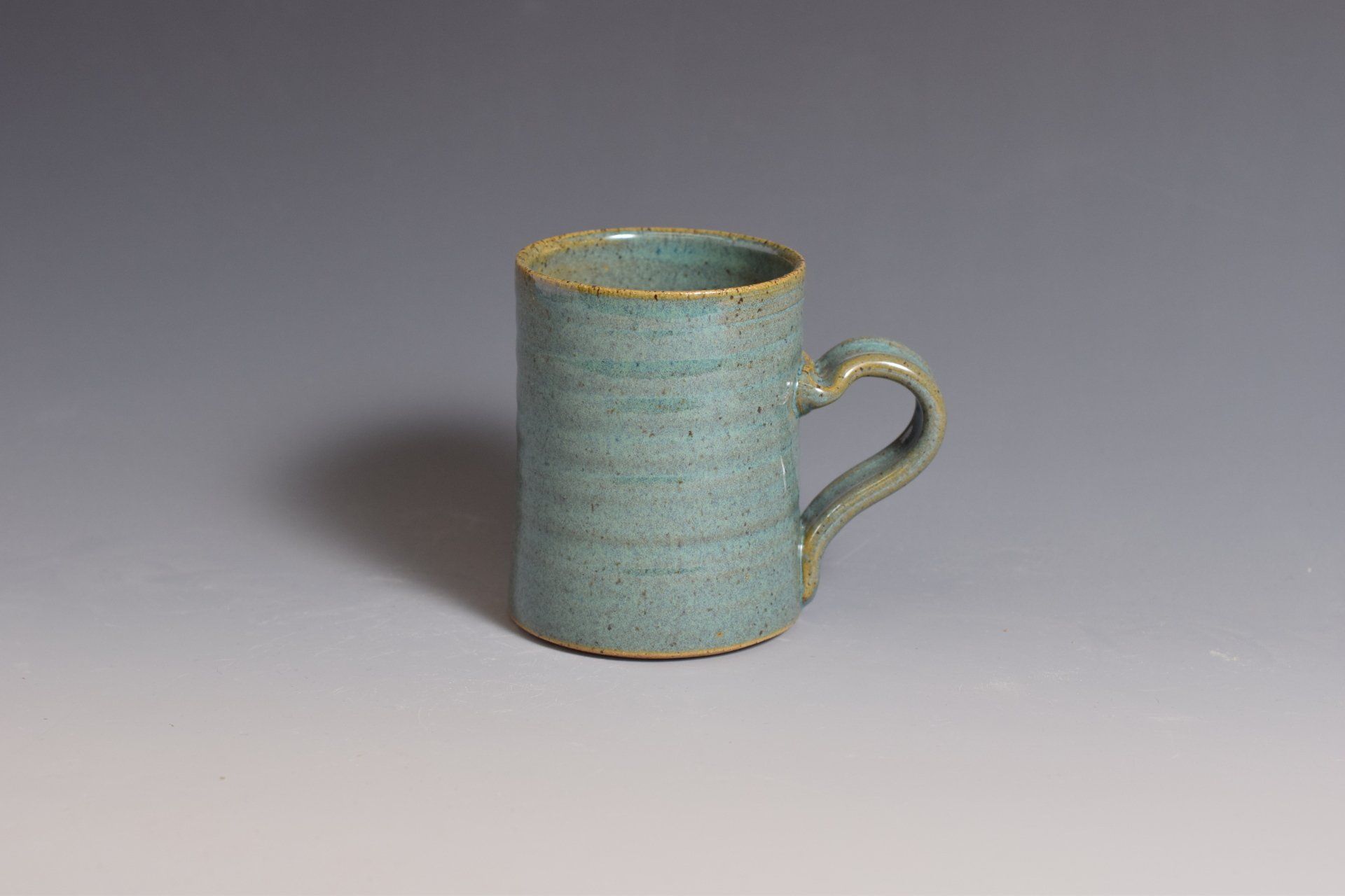 a small blue mug with a handle is sitting on a table .