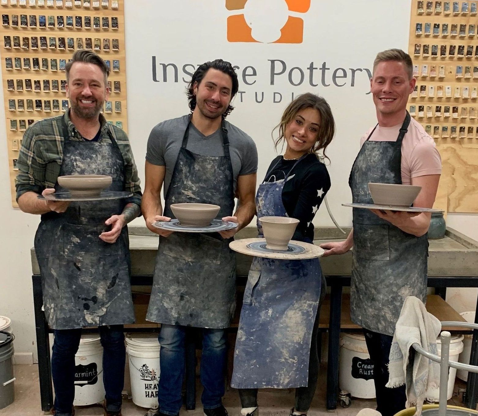 a group of people standing in front of a sign that says Inspire pottery
