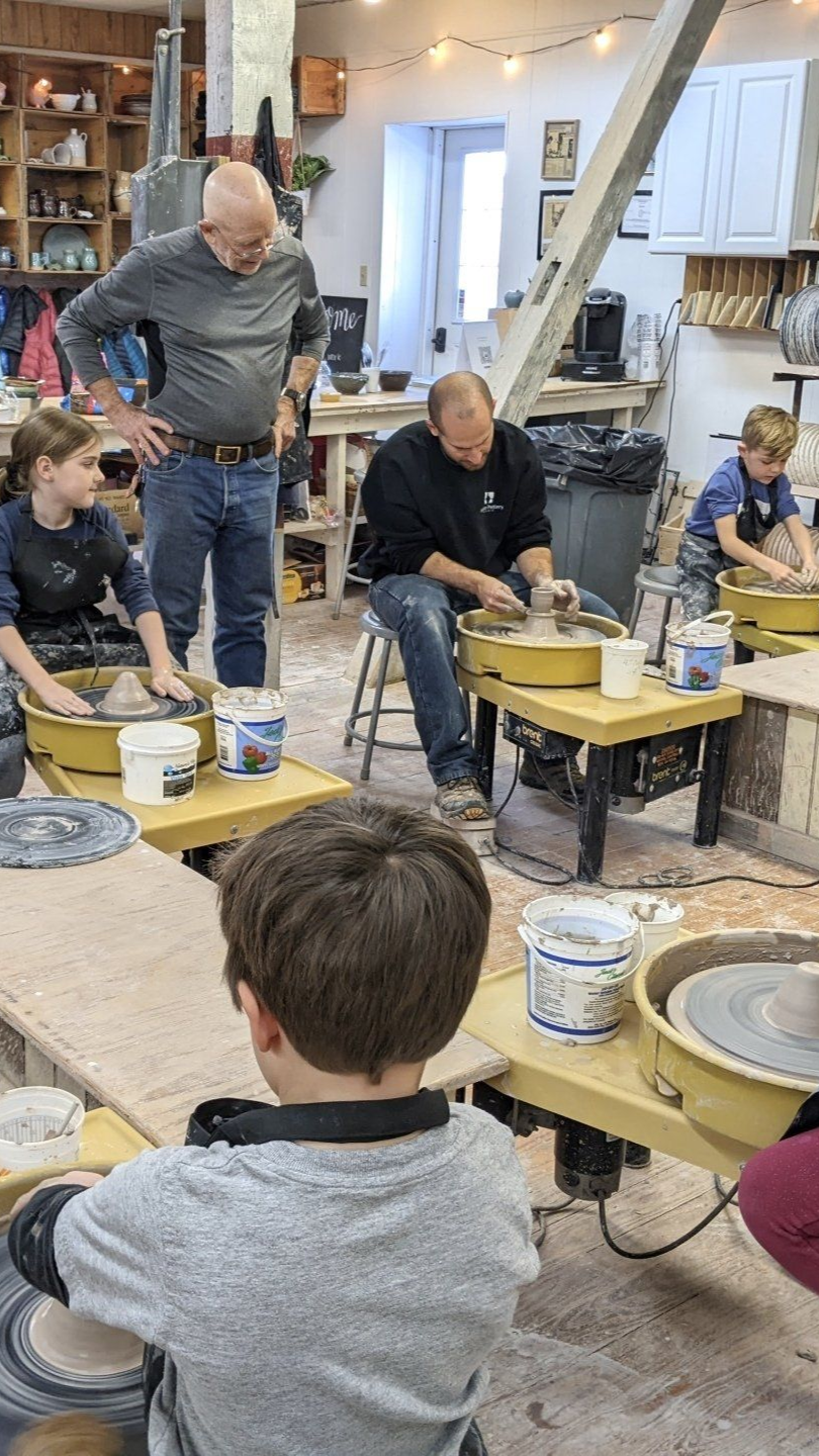 White cosmos flower with yellow center, set in a field of colorful blooms.