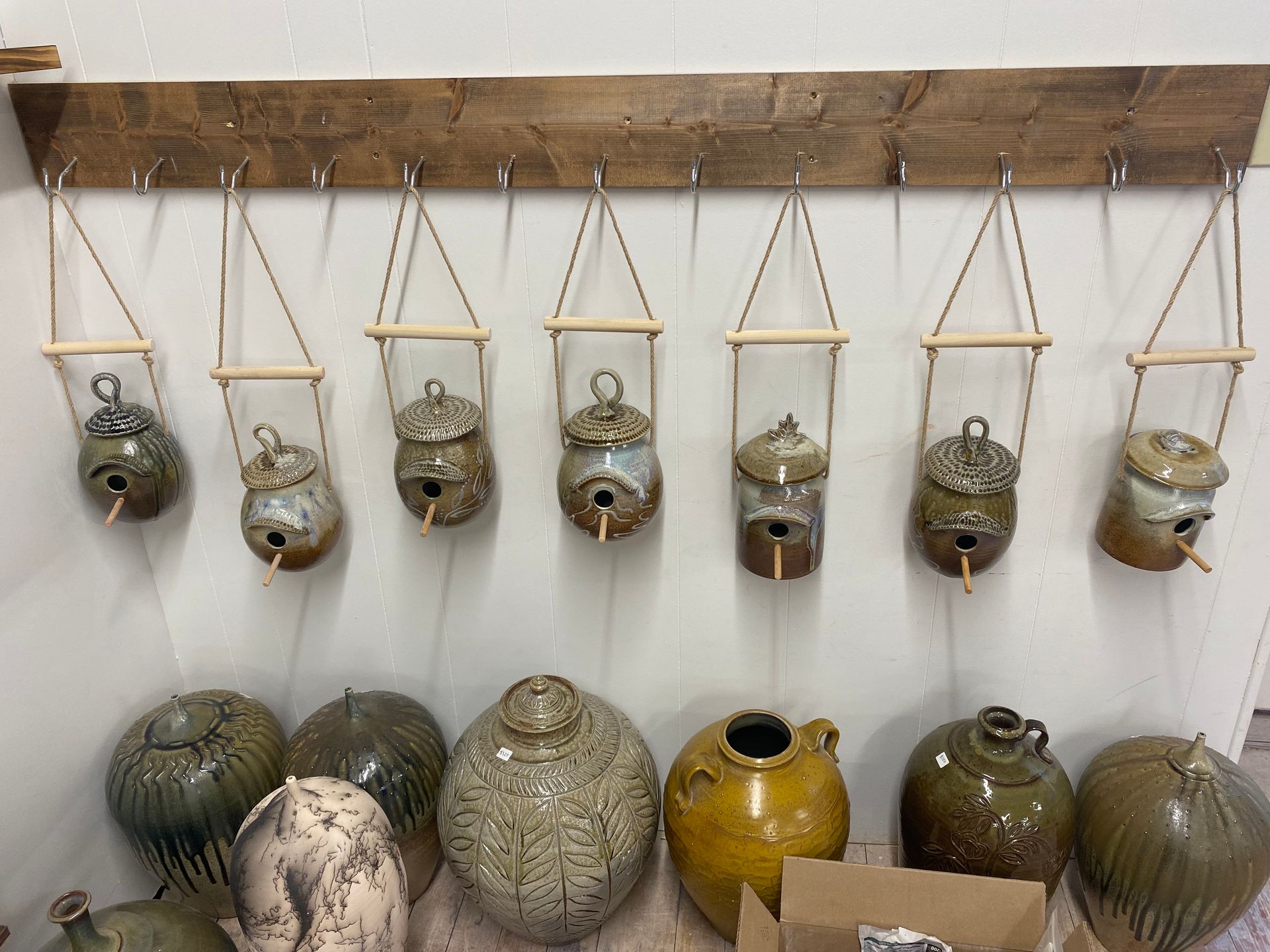A bunch of vases are hanging on a wall.