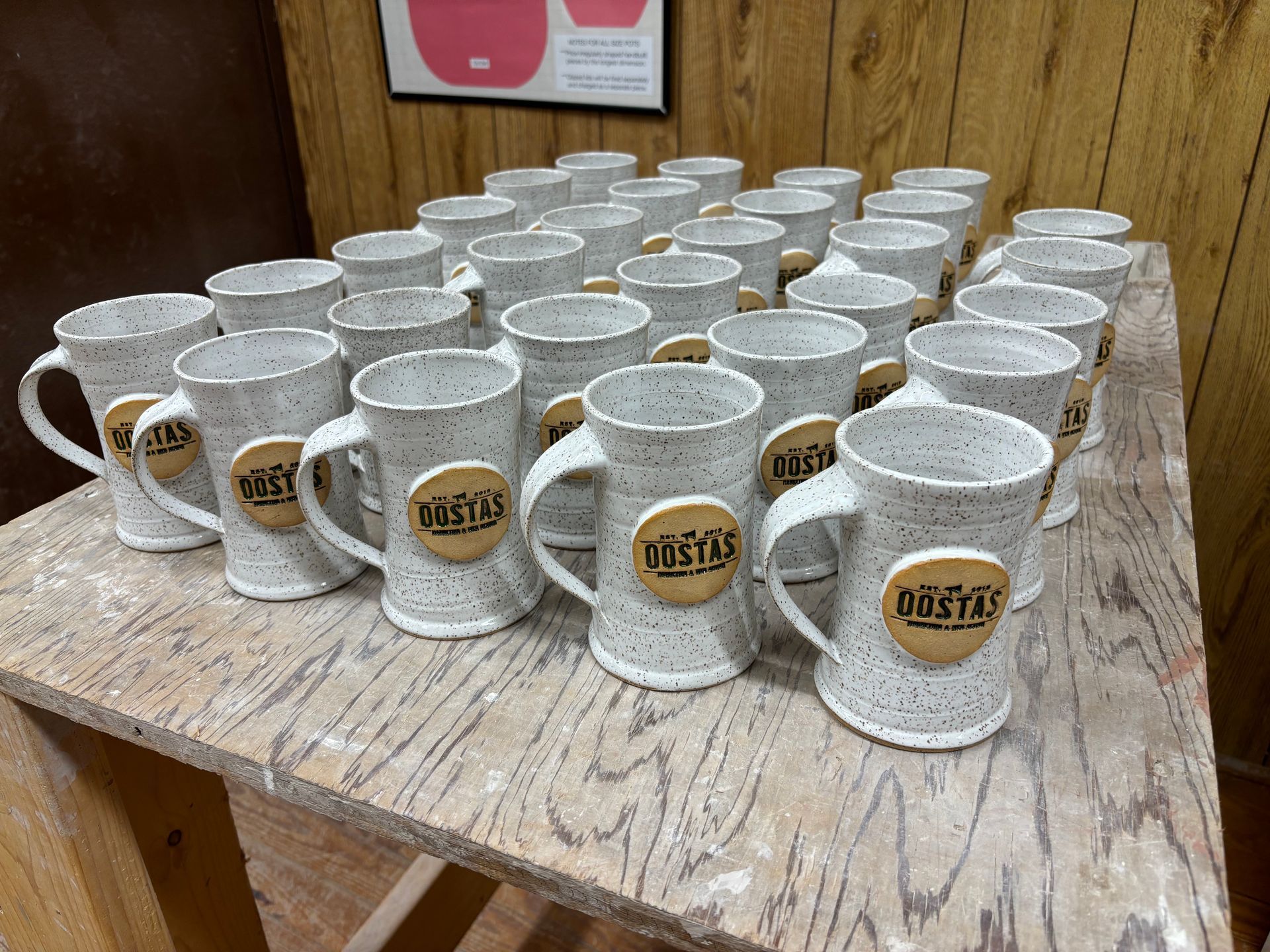 A table topped with a bunch of coffee mugs with the word oyster on them.