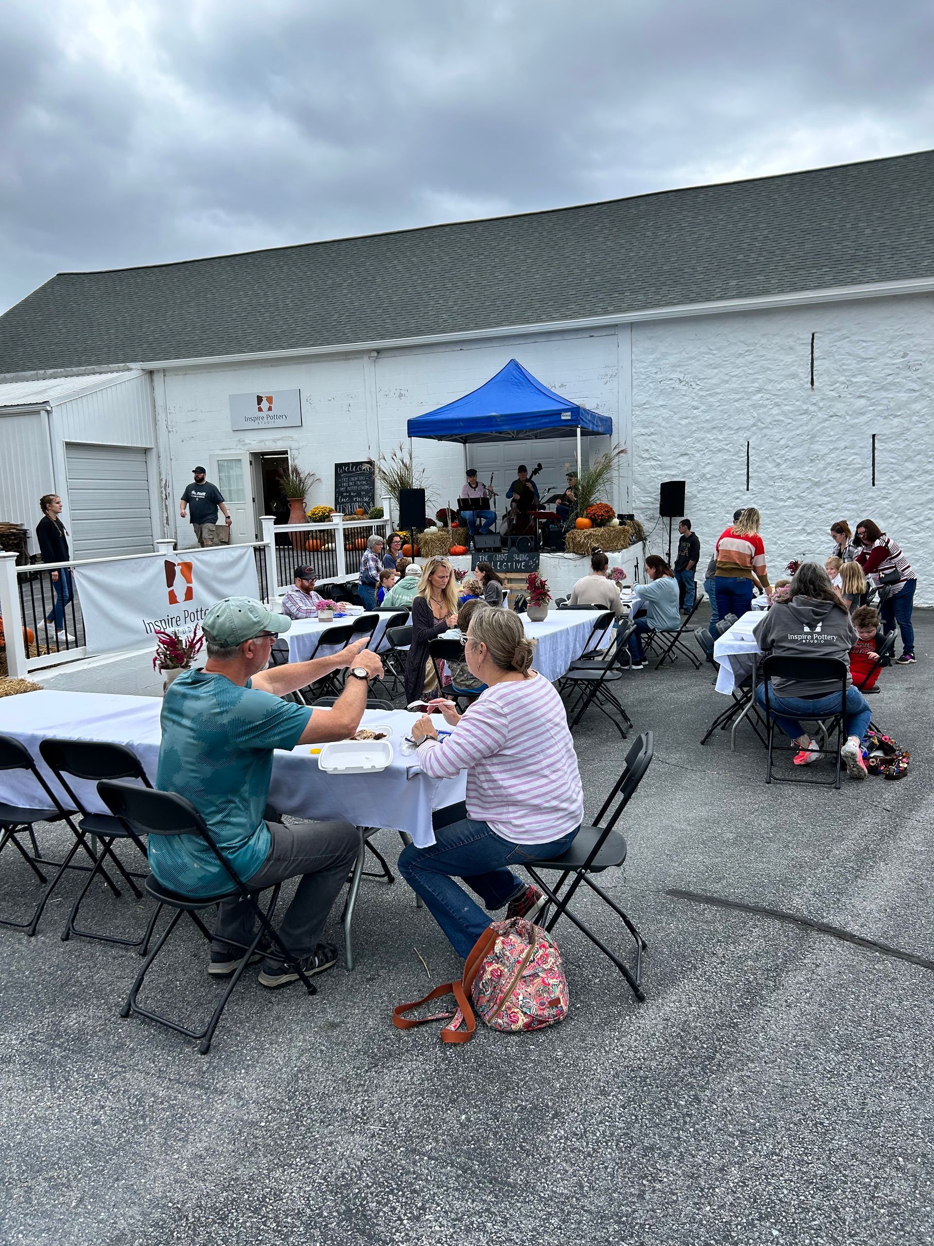 A group of people are sitting at tables outside of a building.