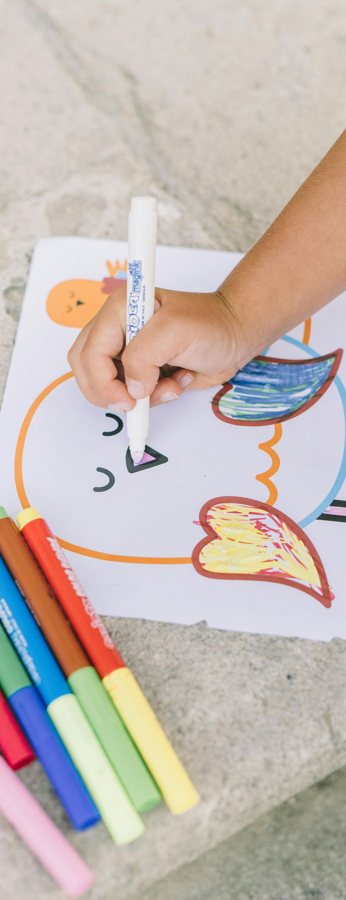 White cosmos flower with yellow center, set in a field of colorful blooms.