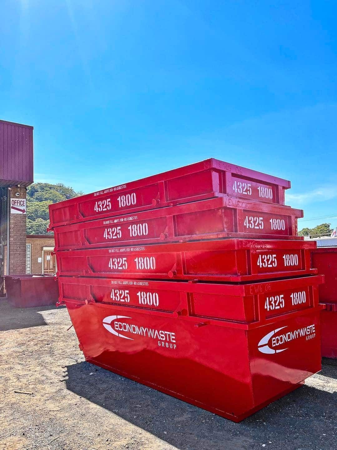 A Red Waste Bins Stacked Outdoors — Economy Waste Group | Skip Bins Central Coast In Narara, NSW
