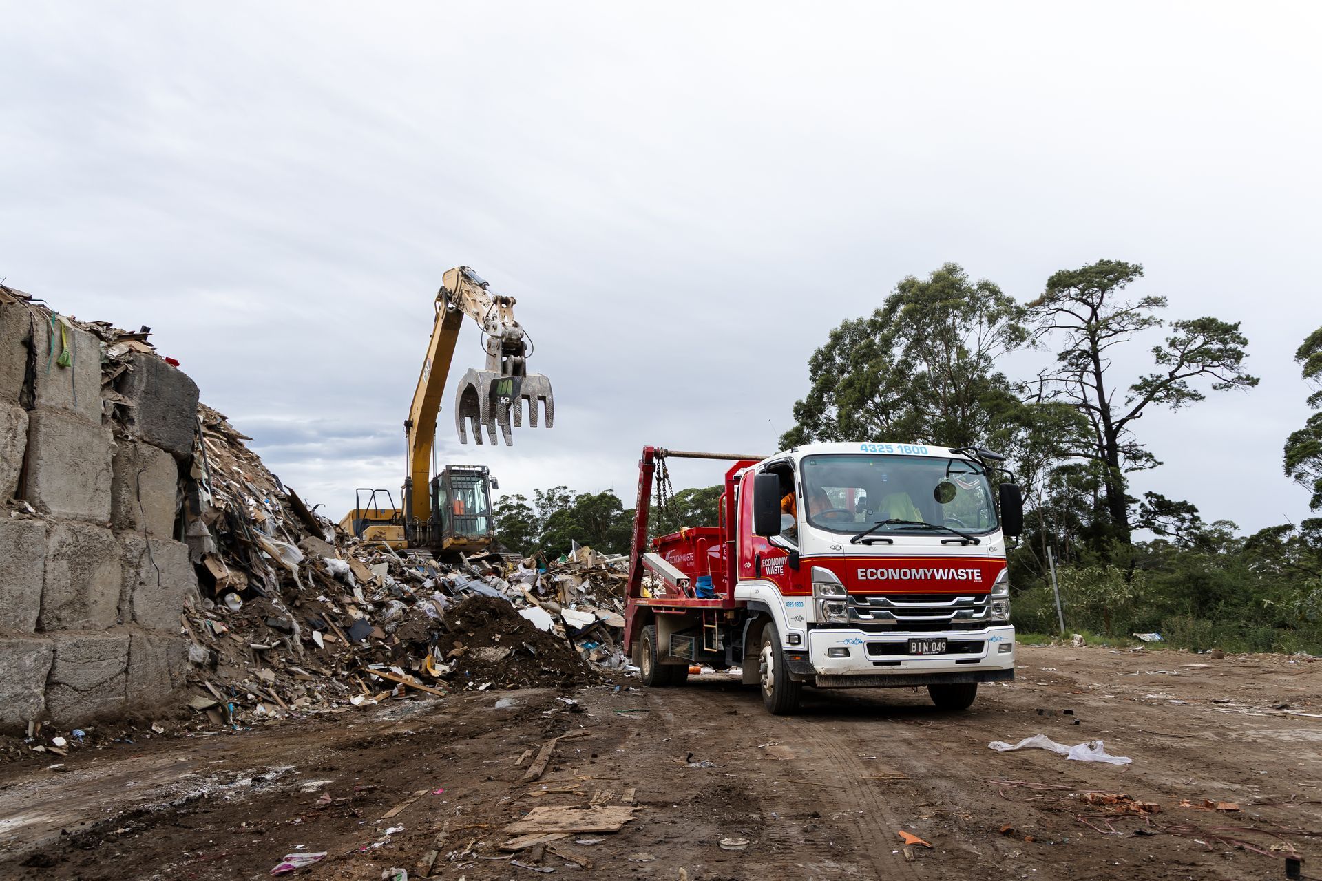 Demolition Site: Excavator Loading Debris — Economy Waste Group | Skip Bins Central Coast In MacMasters Beach, NSW