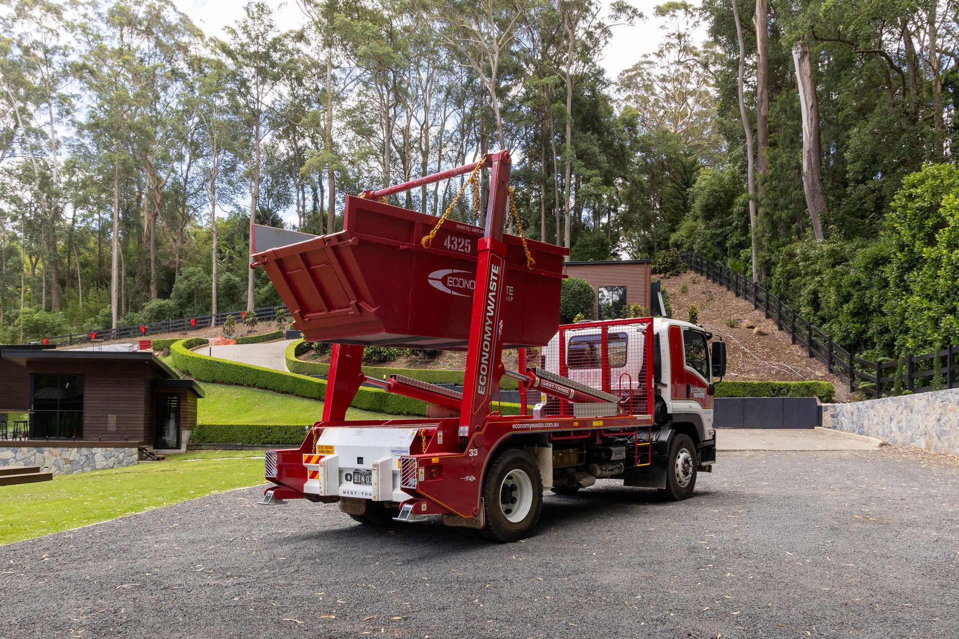 A Family Celebrates in Front of a House — Economy Waste Group | Skip Bins Central Coast In West Gosford, NSW