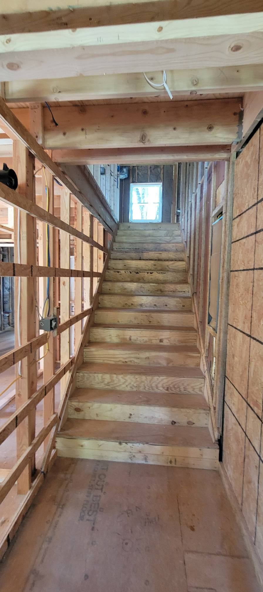 Wooden Staircase Under Construction with Open Railing and Unfinished Walls — Walnut Grove, MO — Big Rock Construction Wooden Staircase Under Construction with Open Railing and Unfinished Walls — Walnut Grove, MO — Big Rock Construction
