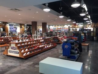 Inside a sporting goods store with shoe displays and apparel racks.