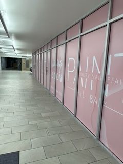 Empty mall hallway with storefronts, one labeled 