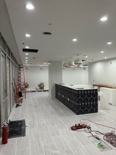 Interior under construction with tile floor, overhead lights, and a patterned island.