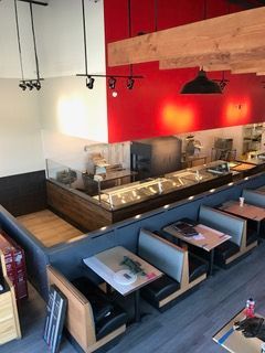 Restaurant interior with red and white walls, booths, and food service area.