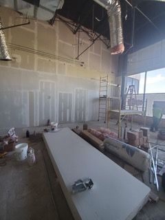 Interior of a commercial space under construction; drywall and equipment visible.