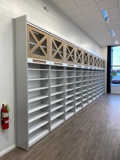 Long row of white shelves with glass-fronted cabinets above, against a white wall.