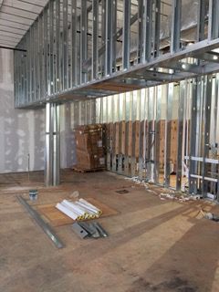 Construction site interior with metal framing and drywall. Unfinished space.