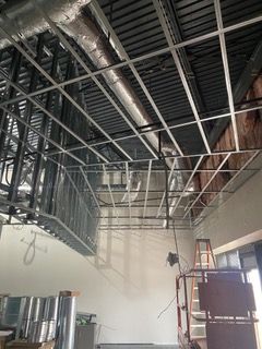Construction site: metal framework for ceiling and walls, ductwork, empty room.