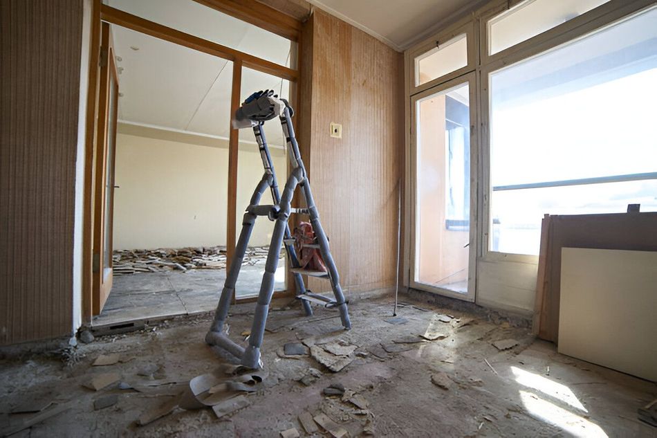 A ladder is sitting on the floor in an empty room.