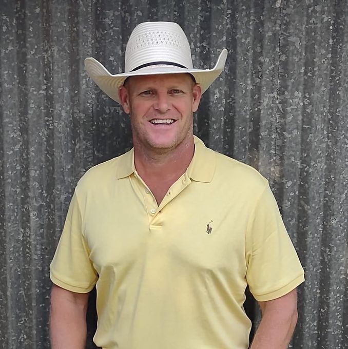 A man wearing a cowboy hat and a yellow shirt