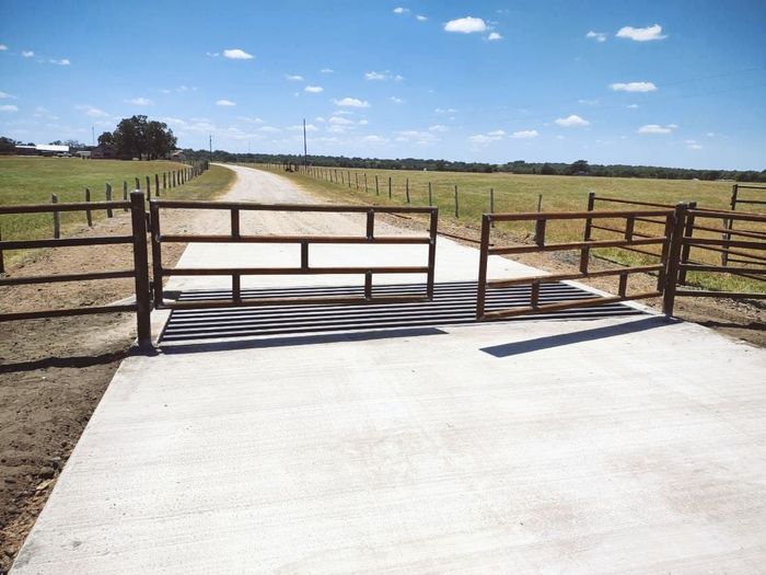 A concrete road with a wooden fence on the side of it