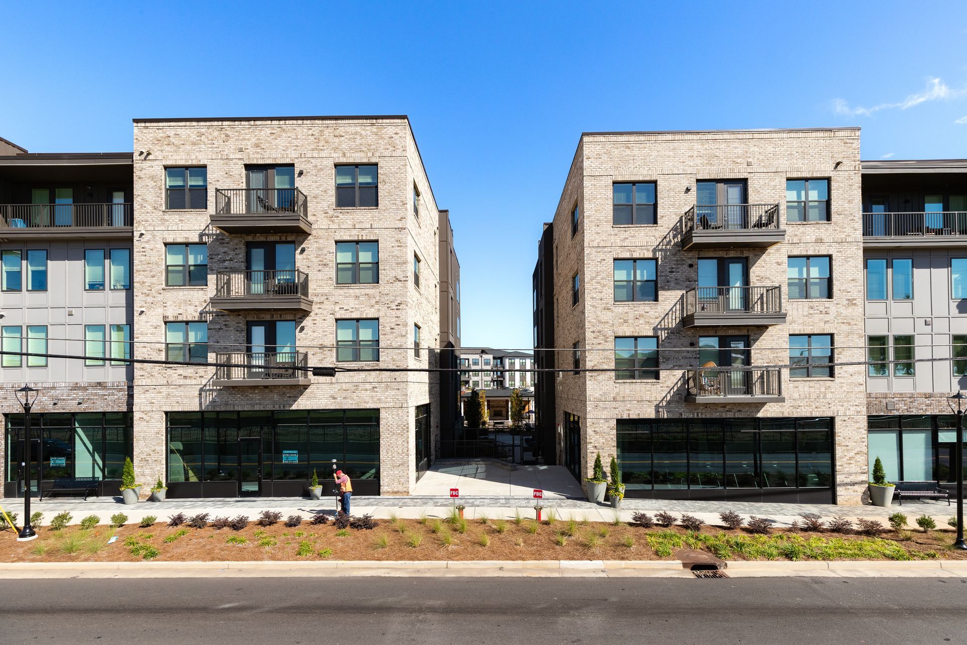 Modern stone apartment buildings with balconies and large windows along a street