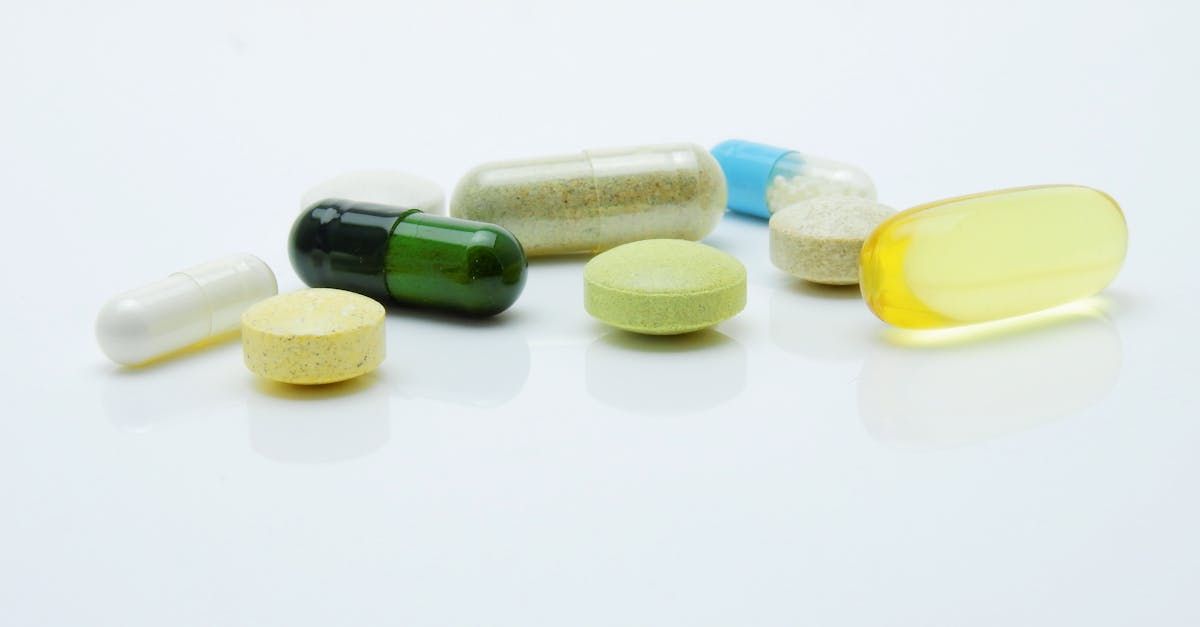 A group of pills and capsules on a white surface.