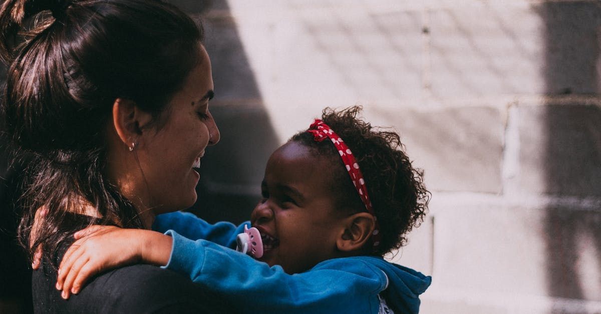 A woman is holding a little girl in her arms.