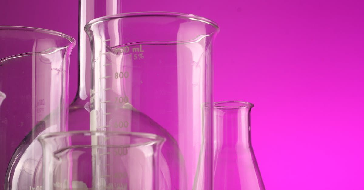 A group of beakers sitting on top of each other on a pink background.