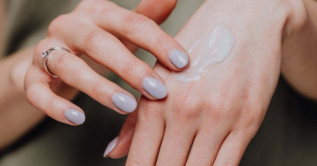 A woman is applying lotion to her hand.